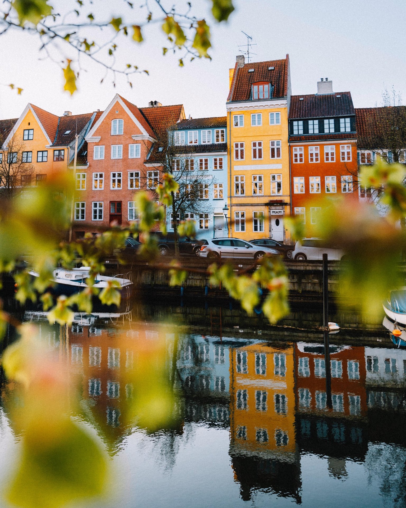 Warm Copenhagen facades reflected along the canal.